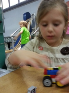 Lily redesigning a lego car she tested on the ramp that failed miserably.